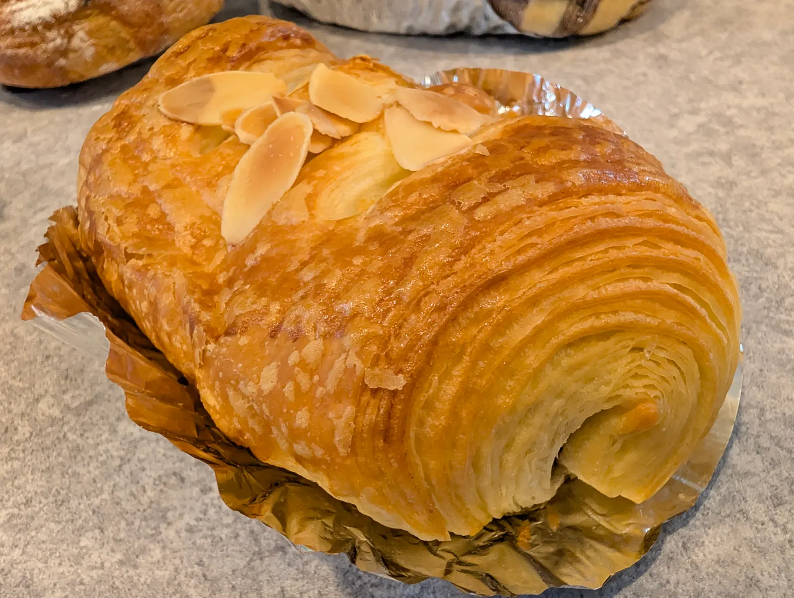 アーモンドがのった層のあるデニッシュ系のパン