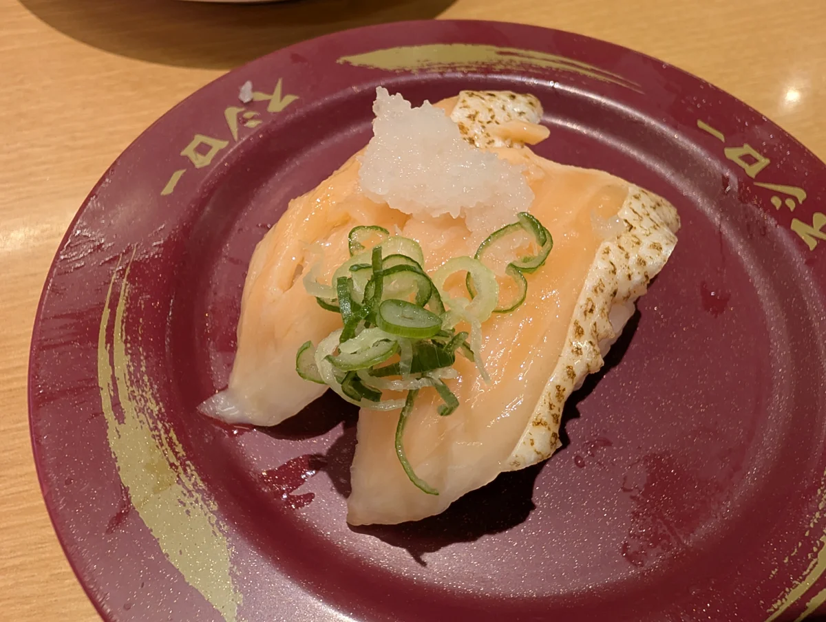 ソースと薬味がのったサーモンの握り