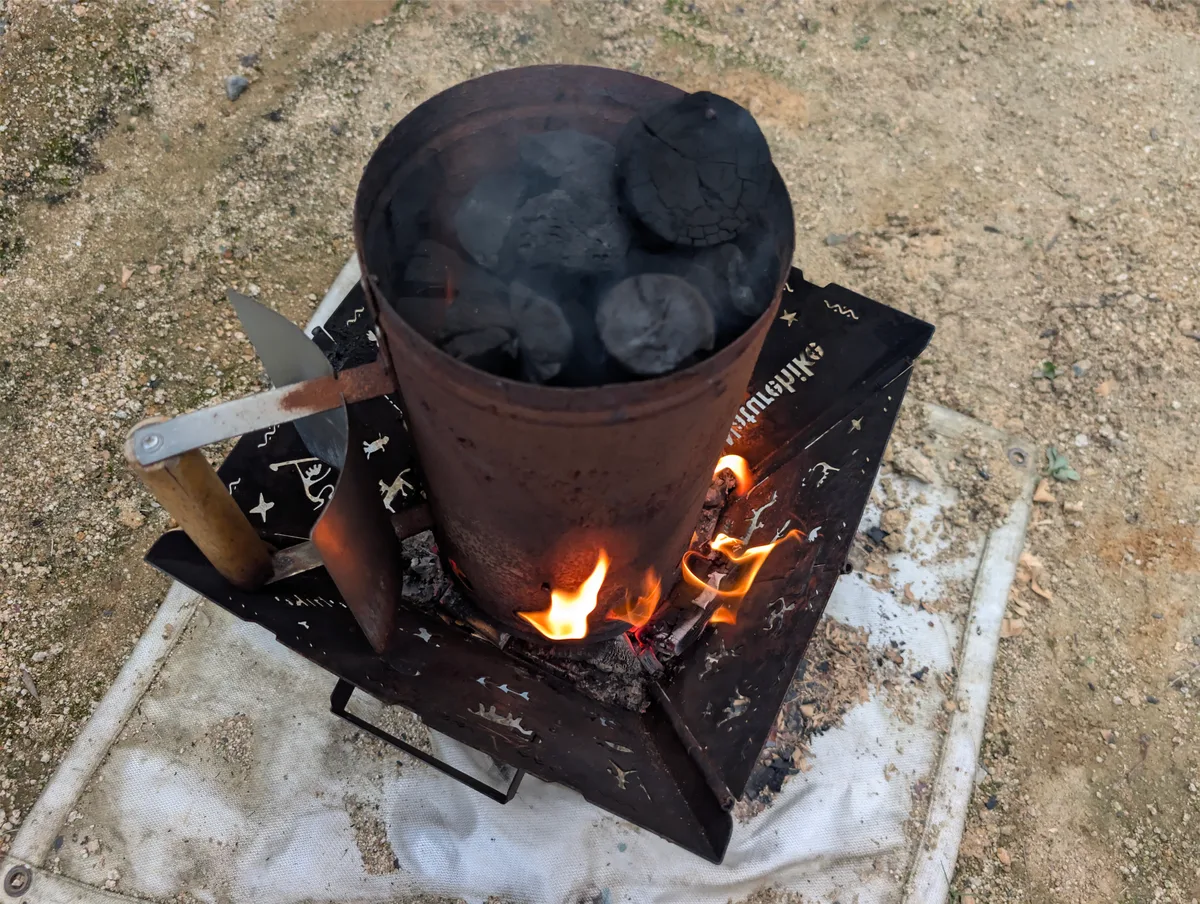 BBQ用のコンロで炭火を準備している様子