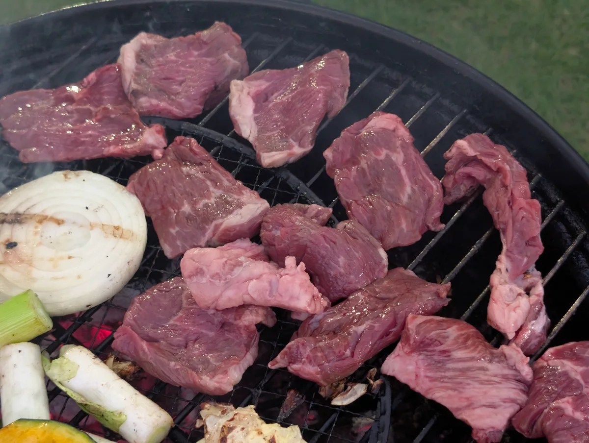 煙が上がるBBQコンロで焼いているカルビ