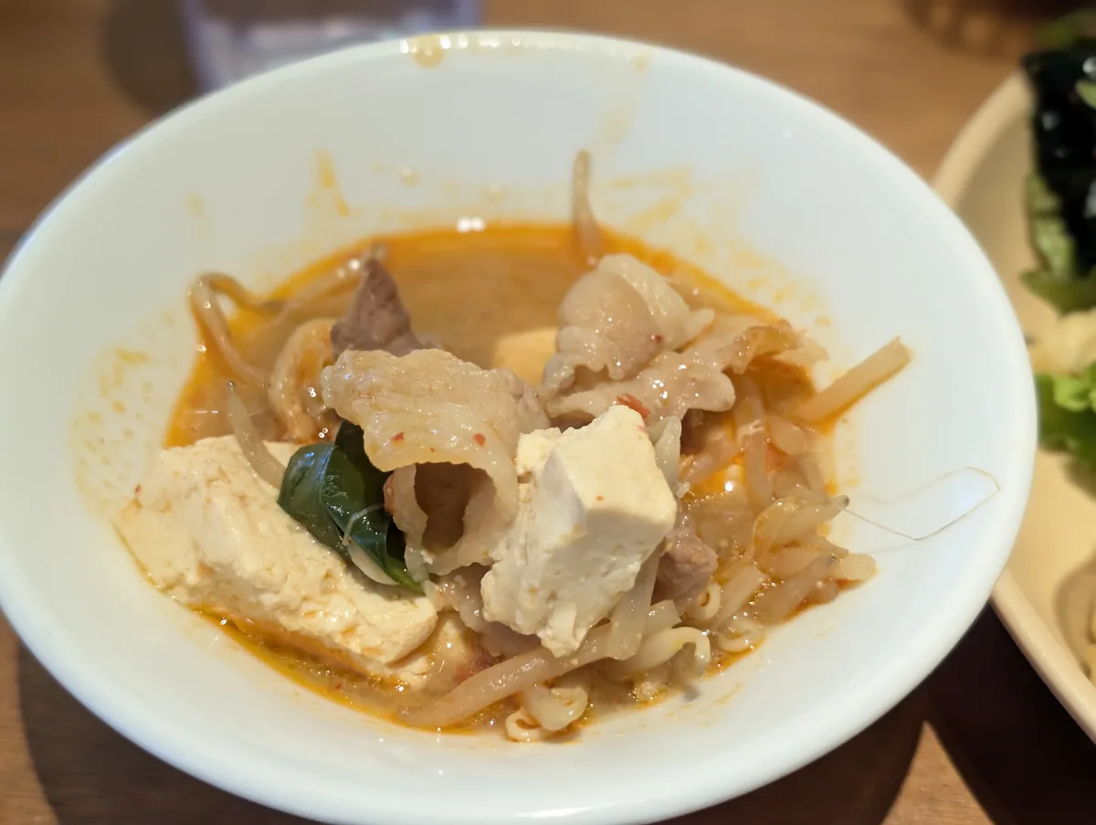豚肉や豆腐と野菜を盛り付けた温かい料理