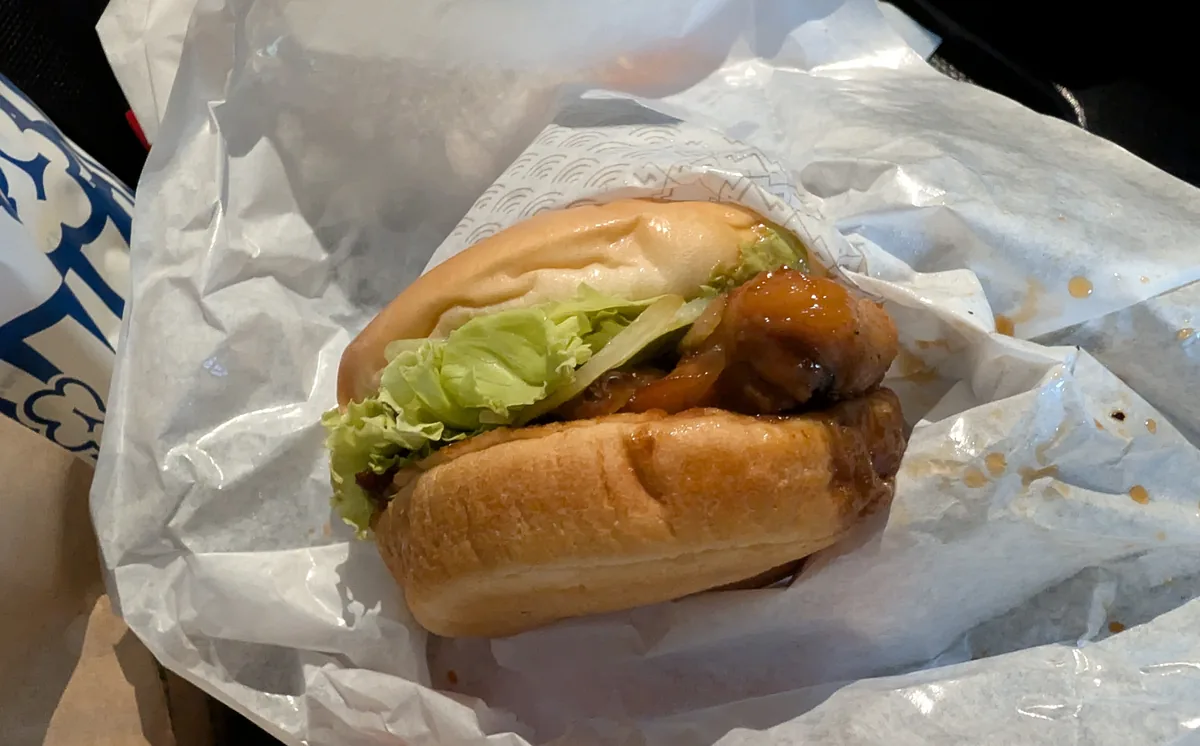 照り焼きソースが絡んだチキンとレタスを挟んだテリヤキチキンバーガー。包み紙を残したまま持つと、車内でもソースをこぼしにくくなります。