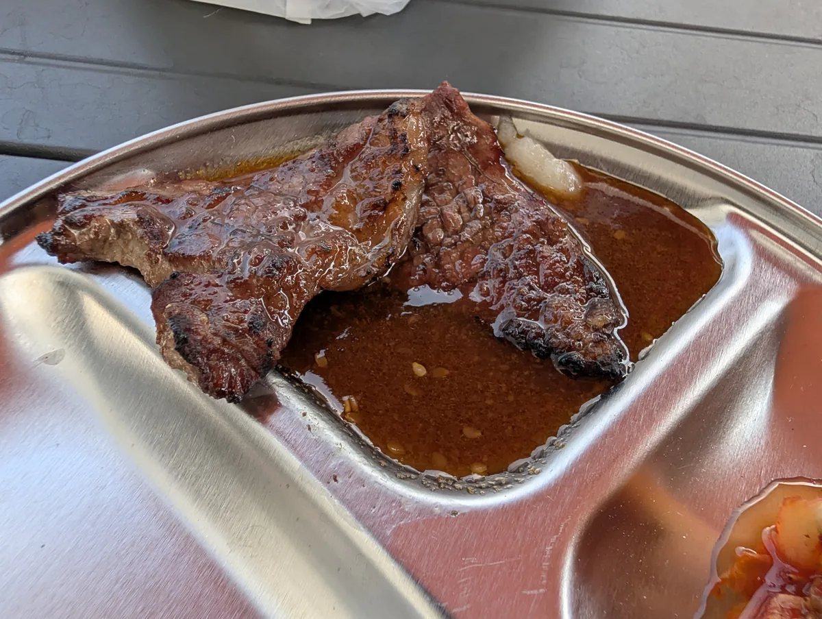 焼き上がったカルビにタレを合わせた様子